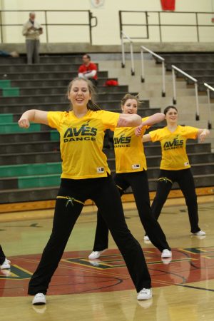  Samantha Weiss, 12 Jennifer Hill, 12 and Lauren Altemuehle, 12 during the winter pep rally. The girls wore their jerseys, underclassmen in green, seniors in yellow. They danced a mix of jazz and hip hop. Photo courtesy of McDaniel’s Photography. 
