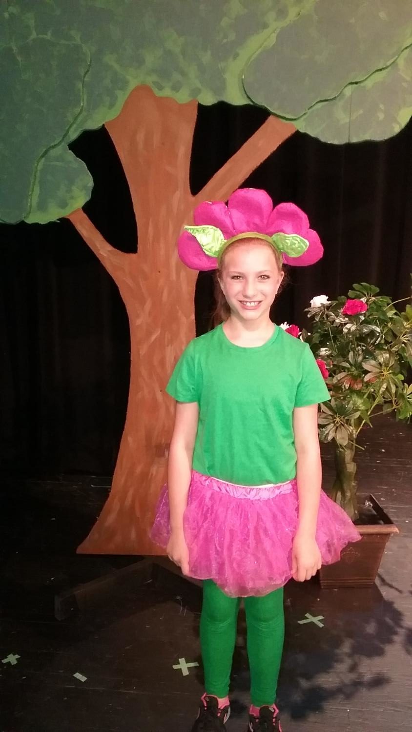 PICTURE PERFECT. Riley Stauffer, third grader, poses after the final performance of Alice in Wonderland.” In the musical, Stauffer was one of the flowers during the song, “Golden Afternoon.” She was also in several other songs throughout the show. Photo courtesy of Maddi Saunders.