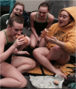 While waiting for their race, the team laughs and eats a quick snack in order to have energy for their race. They enjoy spending time with each other and bonding as a team during their free time.  This gets them relaxed and excited to swim. Photo courtesy of Sarah Horne.