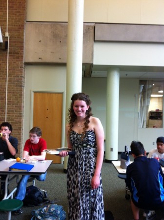 Grace Hertlein, 11 walks around the commons at lunch in a dress provided by Bridal and Formal. She hands out promotional items for local businesses in order to get students excited for Prom. This event is organized by Student Council. Photo Courtesy of Grace Hertlein. 