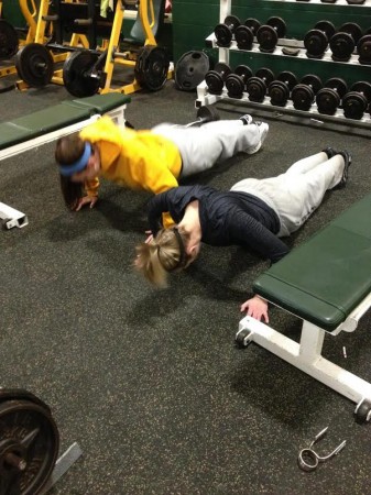 Becca Plaatje, 12, and Liz Izworski, 9, hold a plank in the weight room. Mandatory lifting sessions are held on Tuesday and Thursday mornings at 6:00 a.m. The workouts are designed specifically to focus on areas of the body that softball players often use. Photo Courtesy of Kelly Borman. 