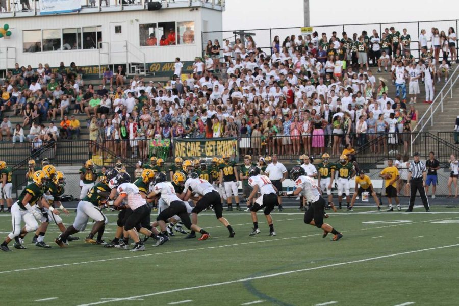 The football team playing during the Ryle game. The Ave Cave in the background is wearing white for the game.  