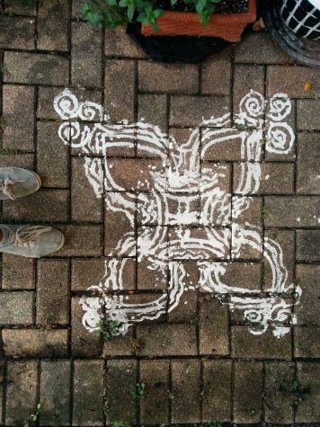 This is an example of puja in front of a house for Navratri Golu. Puja is a symbol of welcome and celebration at an entrance of a home. The design is made with rice flour paste. 