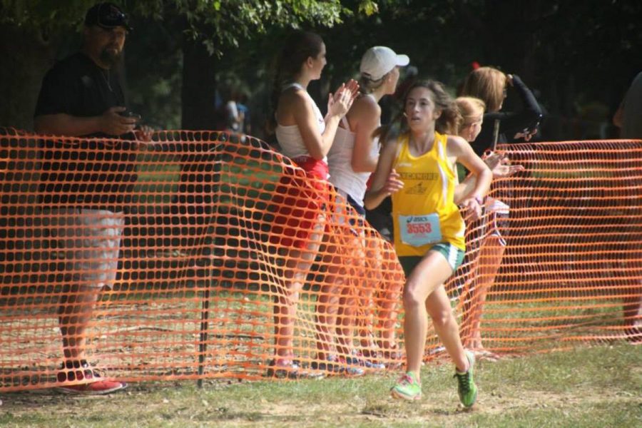 Rose Menyhert, 12, sprints to the finish at the Greater Miami Conference championships. Menyhert led the team to a fifth place finish. Both the boys and girls cross country teams will have to place in the top four at Districts to advance to Regionals. Photo Courtesy of Sarah Guckenberger. 