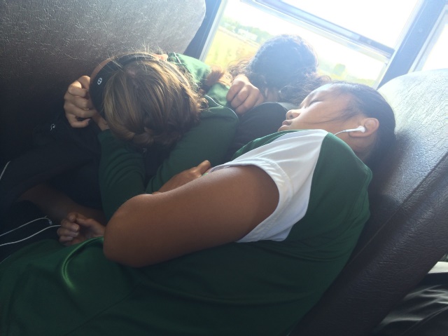 Sophomores Lauryn Klyop, Grace Mather, and Sarita Evans as they head home. The three are exhausted and nap on top of each other. These close friends always sit with or near each other on the way to and from the games.
