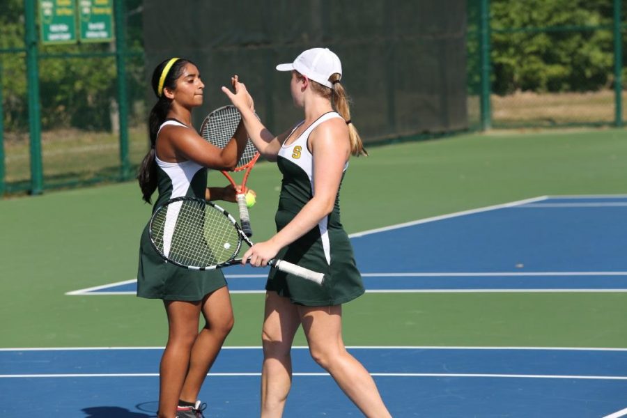 Doubles team Sneha Rajagopal and Brianna Dooley congratulate each other after winning a point against the Princeton team.  They do this after every point to emphasize their teamwork and energy.  