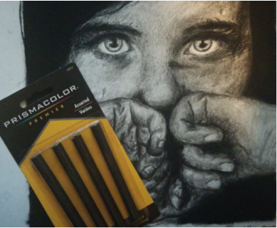 The art piece shown here is done fully with charcoal. It can get pitch black, like on the edges of the piece, or very light and blended, which is shown on the face. Charcoal can come in sticks, like shown, or in pencil form.