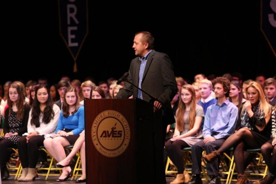 Principal Doug Mader gives a speech at the beginning of the NHS induction ceremony.  He talks to the students about the honorability of NHS and its history.  The students listen intently and appreciate his speech. 