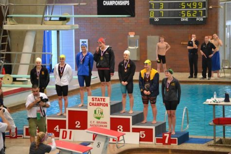 Norris stands on the podium after receiving her medal for her seventh place finish in the 100 fly with a time  of :56.27. Norris injured her knee in the middle of the season, due to this she was  not able to train for a month before the state meet. Last year, Norris got second place in the 100 fly with a time of :55.14, just two one hundredths of a second off of the first place winners time. Photo by Jean Wu. 