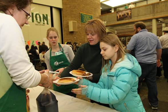 Patrons prepare to enjoy pancakes at the 2014 Pancake Day. Last year more than 2,200 people were fed with over 170 gallons of pancake batter and 26 gallons of syrup. A $6 includes pancakes, sausage, and a beverage as well as seconds. Photo courtesy of McDaniels Photography.