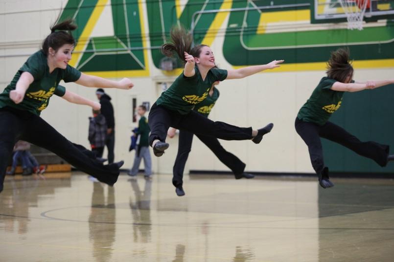 Freshman Riley Krutz, sophomore Hannah Young, and senior Kathryn Tenbarge toe touches during their half time dance. “I’ve been dancing since I was three so I definitely think that helps me pick up the choreography quickly. Also, I am JV football and basketball cheerleader and have been cheering since I was four,” said Young. Photo courtesy of McDaniel’s Photography. 