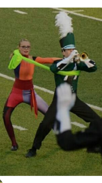Freshman Lydia Cooke and sophomore Enrique Martin perform in the second movement of the show. The color guard and trumpets do a feature which involves stretchy green fabric. Each member of the color guard is paired with a trumpet.