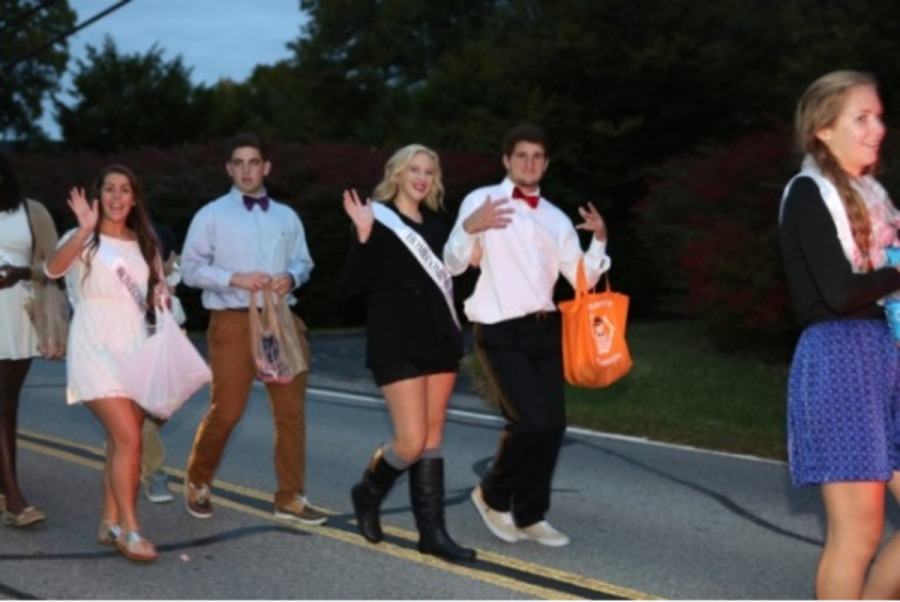 Homecoming court walks in the parade. Seniors Gabriele Kaiser and Gary Traub hand out candy to the crowd. Moving the parade to Friday instead of Thursday is just one of the initiatives to increase school spirit.