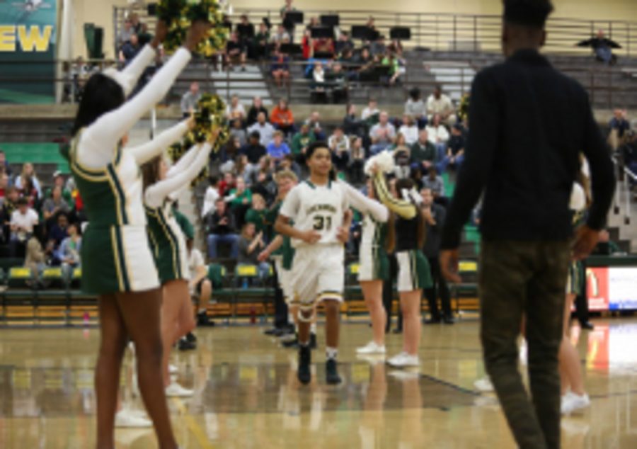 Sophomore guard Christian Kelly walks down the pep line as his name is announced in the opening lineup. As a freshman, Kelly average 17 minutes per game. This year Kelly has already played 20 and 24 minutes.                             