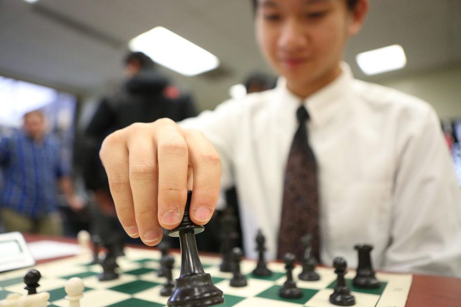 Sophomore Victor Lim picks up pawn piece in the position F-4 during his turn. Lim played second board throughout the season. Lim was selected as “first team” during the GMC competition, meaning he was voted within top ten players.