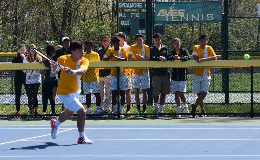 The boys Varsity Gold tennis team and fans celebrate a win against Toledo St. Johns. The team won with a final score of 5-0. Among the crowd were recent graduates Alexander Wittenbaum and David Muskal. 