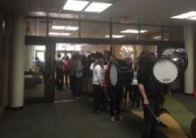 Lead by the drum line, the winning team marches through the school. After walking around the IMC, the procession ends at the front office. Students cheer on the team by lining the hallways.