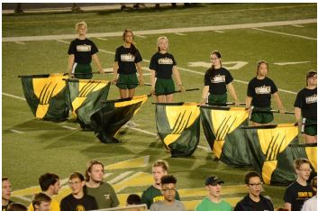 The girls in color guard perform at the homecoming game. One of the guard members, Julia You, 12, was selected as the homecoming queen. As she went through the tunnel of flags, the girls all cheered for her.