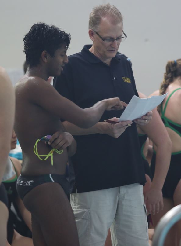Senior Jannen Sivaruban stands with Dr. Dan Carl as he asks the coach for advice. This meet was at home. Sivaruban is on the Varsity team. 
“Give your best, be competitive, but have fun,” Sivaruban said. 
Photo Credits: McDaniel’s Photography 