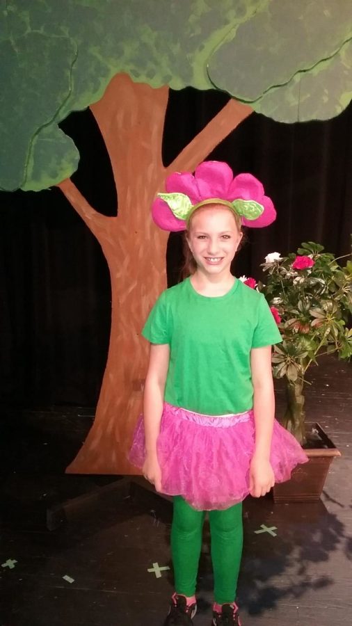 PICTURE PERFECT. Riley Stauffer, third grader, poses after the final performance of Alice in Wonderland.” In the musical, Stauffer was one of the flowers during the song, “Golden Afternoon.”  She was also in several other songs throughout the show. Photo courtesy of Maddi Saunders. 
