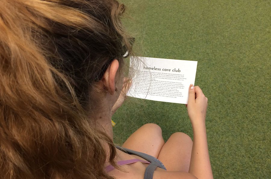 INTRIGUE. Allison Linser, 10, pores over a summative handout distributed at the meeting. Those present viewed a video about homelessness and periods as a supplement to the co-presidents’ address. “I’m so happy to be getting to help the community and I hope a lot more people will join in [the club’s] efforts soon,” Linser said.