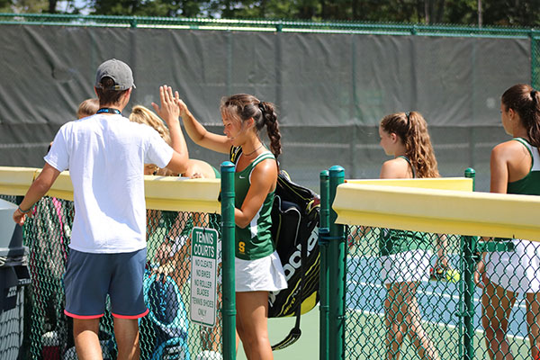 ENCOURAGEMENT. Junior Alex Karev high fives senior Kaitlyn Jiang after a match. High-fives are a trademark of Aves tennis as a way to maintain positive energy on the court.