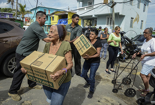 TEAM EFFORT. Hurricane Maria victims receive water and other supplies to sustain themselves. Water and electricity are essentials that parts of the island are still living without. Volunteers and alternative sources of energy are being utilized to aid in recovery.