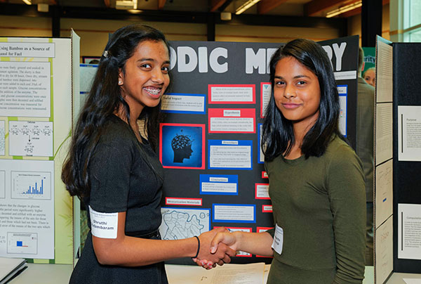 CHANGING THE GAME. Sophomores Debasmita Kanungo and Shruthi Chidambaram are pictured at the science fair last year, presenting their research on how different instrumental music affected memory in the classroom environment. “The most important part of the experiment is that it has some type of a social impact and improve society in one way or another, “ Kanungo said.