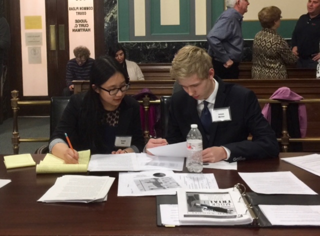 COURT SIDE SEATS. Seniors Jenna Bao and Adam Meller prepare at counsel table at district competition. Both seniors have been in the program since freshman year. The two attorneys were on the side of the defense this season and competed against St. Ursula Academy. Photo courtesy of Yan Xu. 