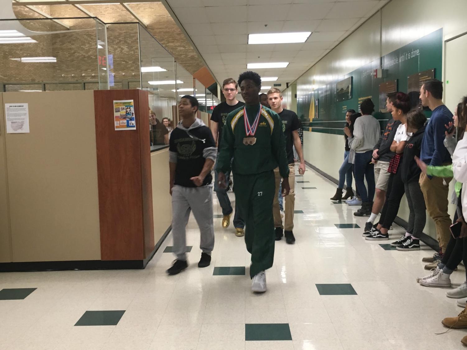 SPIRIT. A walk of champions celebrates the winter track athletes before they head to state. Senior Asa Hodrick ranked seventh in the 200m. Athletes had to rank in the top eight at the event to earn points for their team as a whole.