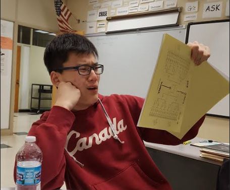 MIGHTY PEN. Fascinated junior Youngbin Lee reads poems from the March Madness Poetry book. Each student gets his or her own copy of the compilation of the 64 poems that made the book. The winning poem’s writer was Nehalem Chudnoff, 11.