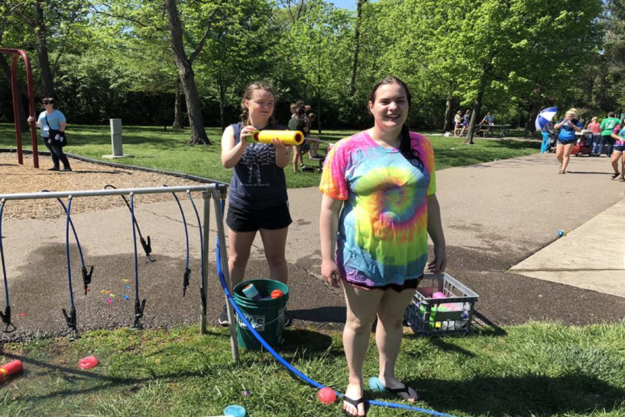 SOAKED. Junior Hannah Taylor sprays senior Lily Steward with a water gun. The water play station included water activities such as squirt guns, a water sprayer, and other types of water toys. Further out in the field students used a sling shot to shoot balloons out in the grass. 