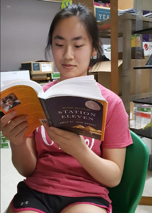 GET COMFY. Junior Jessica Lu reads the AP Lang novel “Station Eleven.” This adventure book has been a favorite amonst many students who take AP Lang. Students’ grades for the discussion board on Blackboard have been based on insight levels, sharing ideas consistently, and creating discussion rather than talking about only one’s own ideas. Many AP Lang students are now moving on to AP Literature and Composition and will be reading their summer reading books and poetry over the summer.