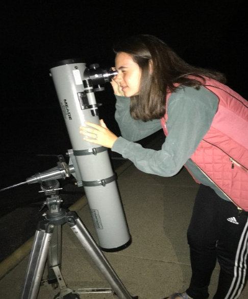 SEARCHING THE SKY. Astronomy Club president Peyton Gilhart looks through a telescope. Some of the telescopes were brought by science teachers, while others are owned by club participants. The telescopes that were set up at the meeting provided an interesting opportunity for students to see different planets. “I enjoyed spending my Saturday evening learning about astronomy but having fun with my friends,” said Sarah Schrantz, 10.
