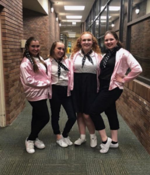 LIGHTS, CAMERA, SMILE. Juniors Erin McDonough, Maggie Ballard, Bethany Brown, and sophomore Brynn Gvozdanovic posed for photos during the “Grease” rehearsals. They dedicated eight weeks of hard work and time into this musical, building a theatre community and friendships. “Since this cast is relatively small, we all have grown very close during the process...I just feel like everyone trusts each other a lot, and that’s really important for a show, everyone relies on each other for so much,” McDonough said.