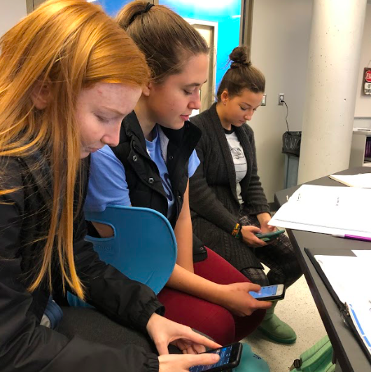 DISTRACTED UNDER DESKS. The introduced cell-phone policy in the beginning of the year has proved to be ineffective, with students still on their phones during class. SHS has implemented many rules on these devices, however, cell phone usage during school has barely decreased, if any at all. 