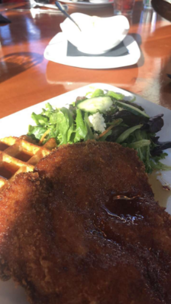 FOOD GALORE. The chicken and waffle is served with maple syrup and hot sauce and a side of salad. The chicken and waffles is a great meal for any time of the day. “The chicken and waffles is by far the best thing on the menu,” said Ariane Clerc, 12.