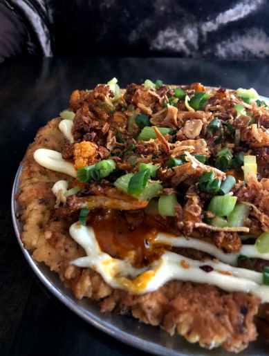 SPICY. The Japanese pancake called Okonomiyaki was covered with cauliflower, sauces and some other vegetables. “I finally chose to eat the pancake as it seemed to be one of the more mild items on the menu,” said Ally Zimmerman, 11. 