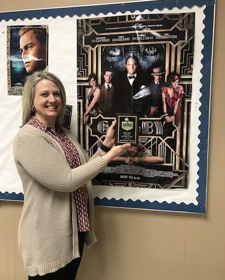 STRIKE A POSE. English teacher and Varsity AQT coach Mrs. Laura Newton poses with her plaque declaring her the GMC Coach of the Year for AQT.  Newton looks forward to seeing the team compete on April 6 at Regionals. “It was exciting… I like coaching AQT so I don’t really need the accolades but it was fun,” Newton said in response to her reaction to winning the spot.