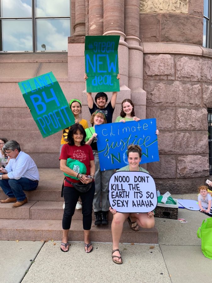 A TEAM EFFORT. Senior Caroline Skwara, top right, poses with her fellow organizers at the Cincinnati Youth Climate Strike on Fri., Sept. 20. Creative signs like Skwara’s handmade “climate justice NOW” poster and fellow organizer Reilly Ackerman’s (bottom right) poster, which references a popular Twitter post, served as a way for each striker to express themself and connect with other teenagers. 
