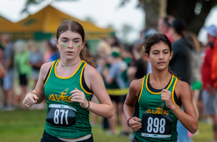 Ariana Hurst, 9, and Sydney Magee, 9, continue to pace themselves as they run a cross country race.