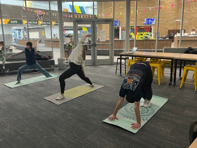 Daniel Arrigain-Golubic, 12, Ellie Johnson, 12, and Kira Iovenko, 11, perform downward dog and warrior pose in Yoga Club.