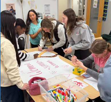 Herstory group members meet to create hall signs for Women's History Month that they will later hang at SHS.