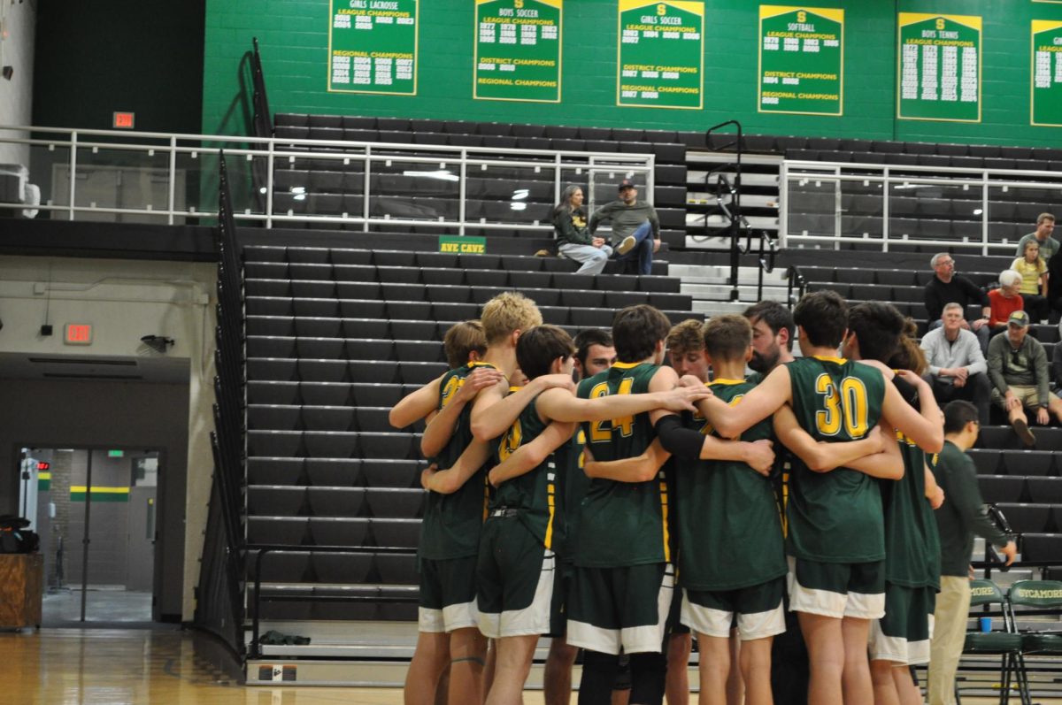 The mens' volleyball team huddles together during their volleyball game's intermission.