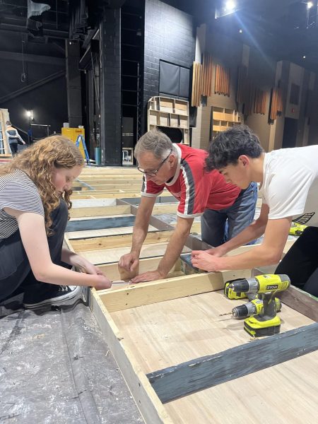 Members of the cast work on constructing part of the set with John Kinsinger, director of the stage crew.